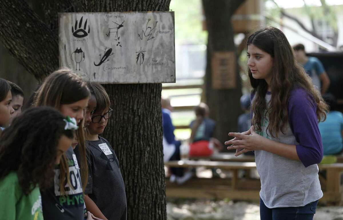 Bradley Middle School seventh-grade student Catherine Gardner (right) talks about how indigenous people painted to communicate with a group of Cibolo Green Elementary fourth-grade students during a tour of Millsprings Cabin on Thursday, May 18, 2017. Texas history teacher Michael Bailey, who in the last month won both the H-E-B Lifetime Achievement award -- the highest teacher award, which gives $25,000 to him and $25,000 to his school -- and the Daughters of the Republic of Texas "Outstanding 7th Grade Texas History Teacher Award," giving $750 to him and $1,000 to his school. Bailey has taught at Bradley Middle School in NEISD for 24 years and not after he started teaching at the school, he had the idea of bringing history to life and with the help of then-principal Bill Boyd brought a 180-year-old log cabin that originated from Kentucky onto the school campus. From there, Bailey expanded around the cabin and added several other buildings based on historical landmarks such as a general store, an old school, a livery all with the notion of enhancing students understanding of Texas history. Furthermore, Bailey has his students act as docents at the grounds which is called, MillSprings Cabin - a Texas Learning Facility. Students gain other skills like speech, public relations, problem-solving along with Texas history. So far, over 7,000 Bradley students have gone through the program according to Bailey. And over 40,000 students have visited and toured the facility. Bailey said he has seen former students venture into education and have even brought their children to tour the site. "I've done it long enough that it's hit that point and it's just fun," he said. "The history will come and go. But the life skills that I'm teaching them out here, dealing with people, public relations, that makes you feel good." (Kin Man Hui/San Antonio Express-News)