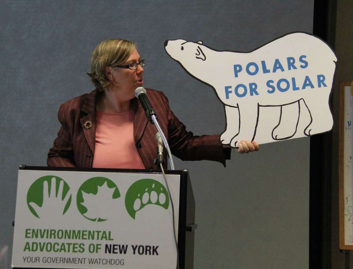 Former EPA regional head Judith Enck holds up a climate change protest sign at a speech Wednesday.