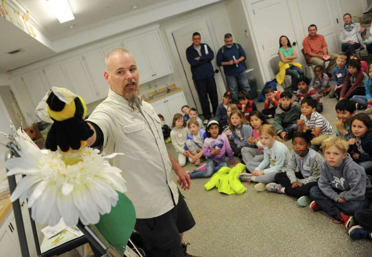 Audubon Greenwich Education Specialist James Flynn demonstrates how bees pollinate flowers to a group of International School at Dundee first-graders on a class trip to Audubon Greenwich in Greenwich, Conn. Wednesday, June 7, 2017.