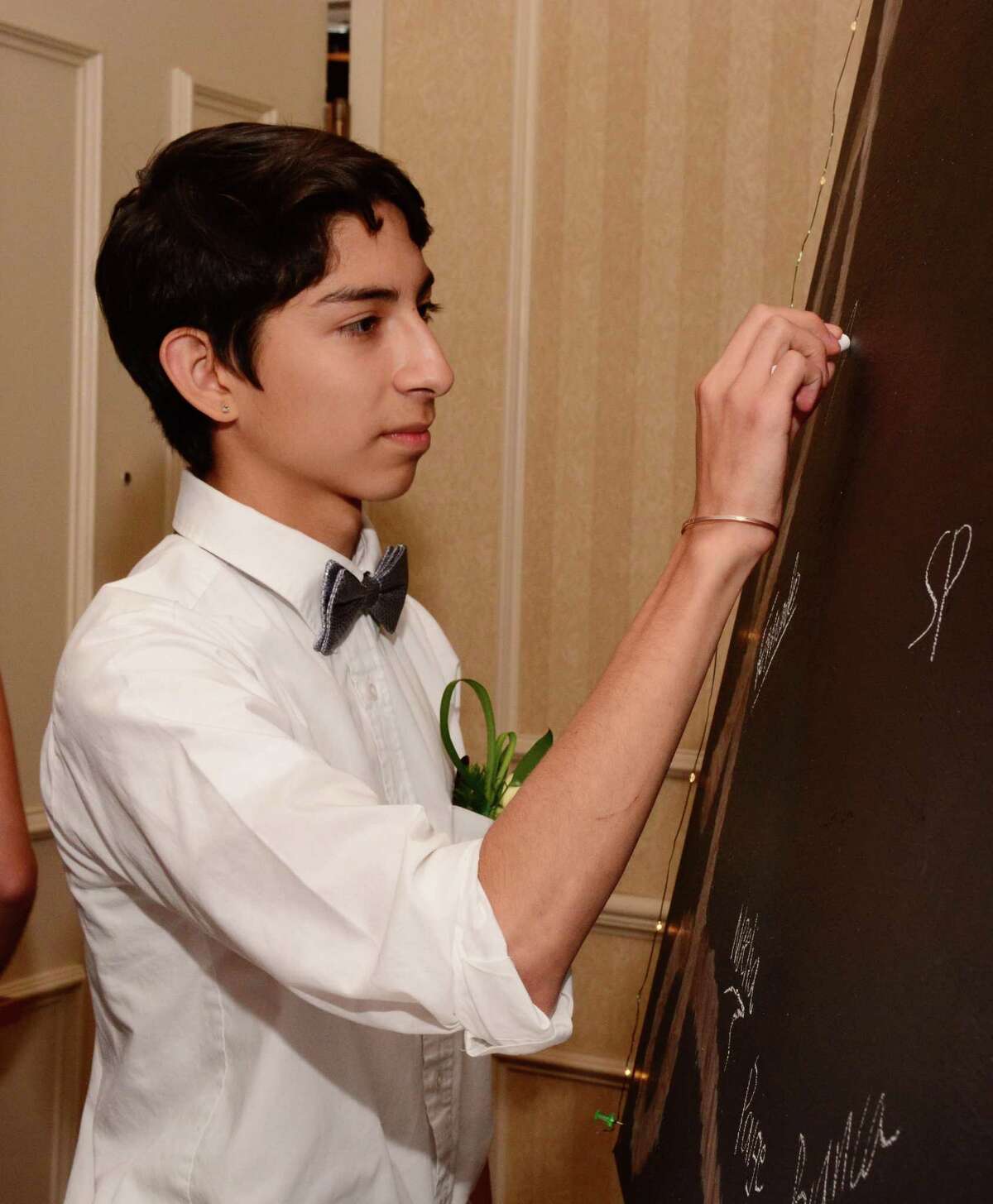 Arturo Ortega, 16, from Washington signs the board at the Shepaug Valley High School prom at Wyndam in Southbury on Saturday May 27, 2017.