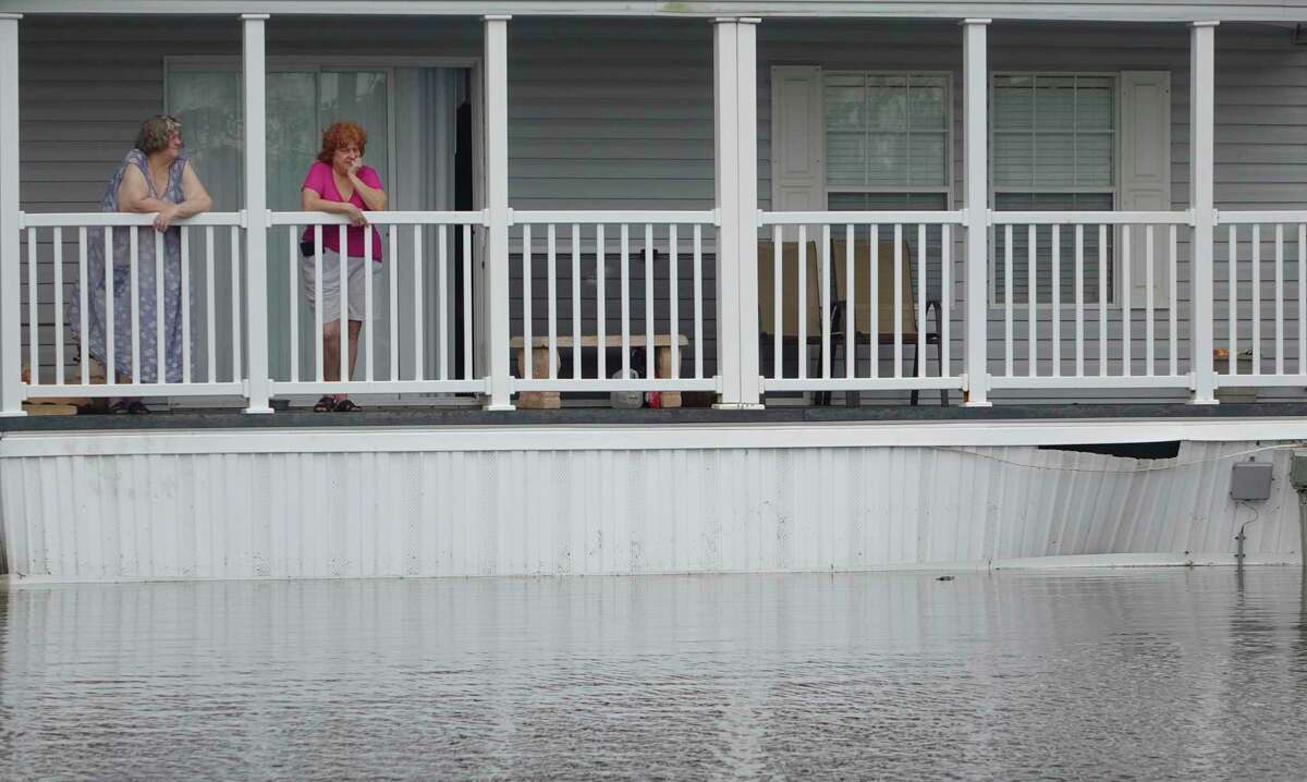 Gail, left, and Leslie Ross look out at the flooding around their home in Sunshine Village, Wednesday, June 7, 2017, in Davie, Fla.. Several days of constant rain has caused flooding throughout Broward and Palm Beach Counties. (Joe Cavaretta/South Florida Sun-Sentinel via AP)