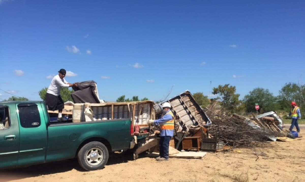 More than 30 Webb County employees and community volunteers assist El Cenizo residents in picking up and disposing of unwanted items on Tuesday.