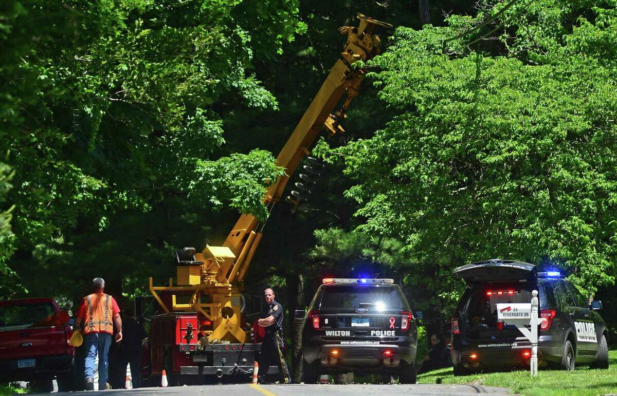 Wilton Police and Eversource employees investigate a workplace accident scene on Rivergate Drive in Wilton, Conn. that killed 44-year-old Marco Silva of Danbury on Thursday, June 9, 2016.