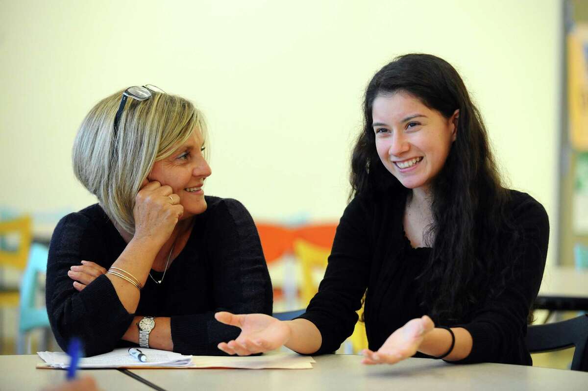 Beverly Reyes, 18, right, and her Starfish Connection mentor, Maria Millan, share one of their stories from the program.