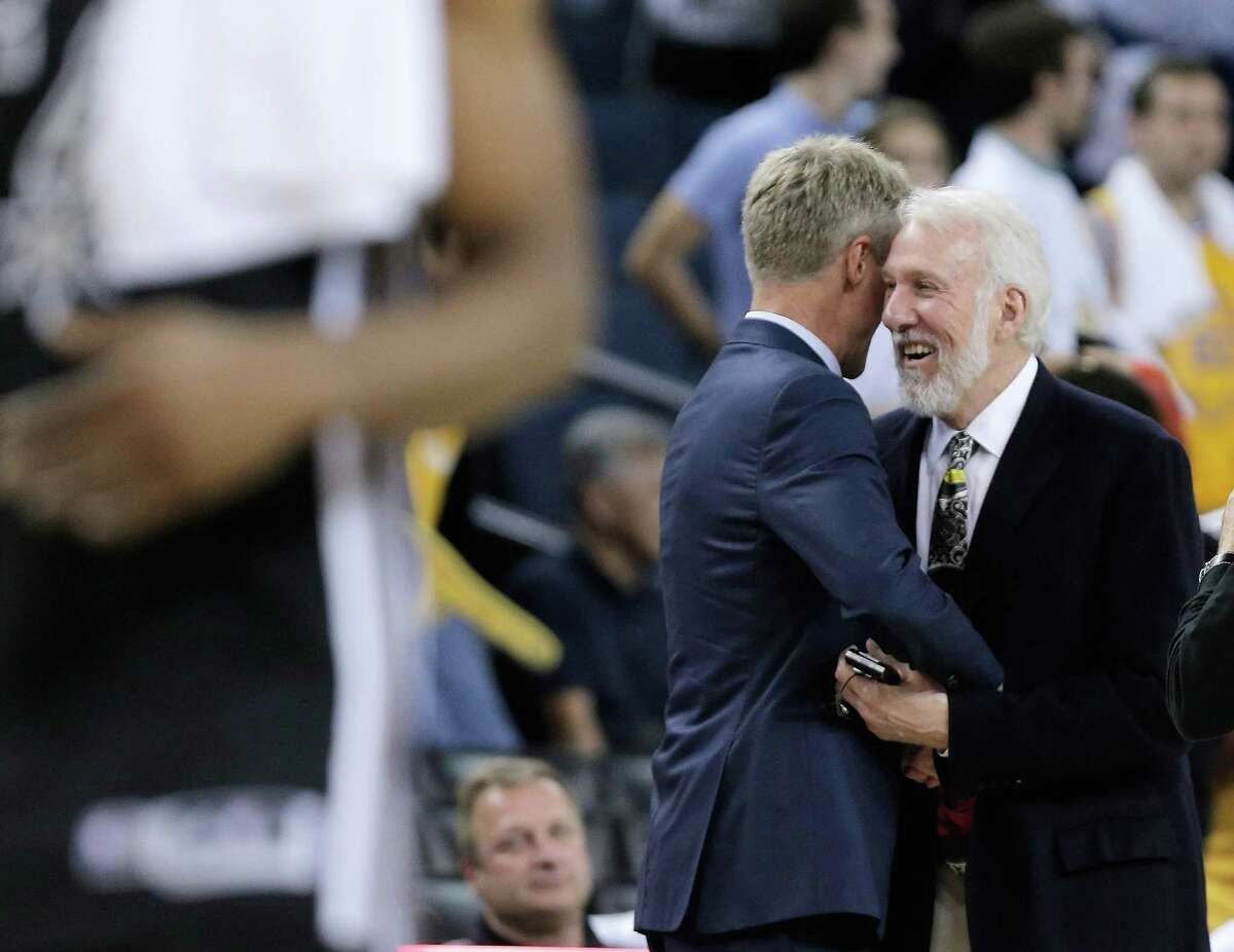 Steve Kerr (left) hugs Gregg Popovich right after game in the NBA regular-season opener at Oracle Arena in Oakland, Calif., on Oct. 25, 2016.