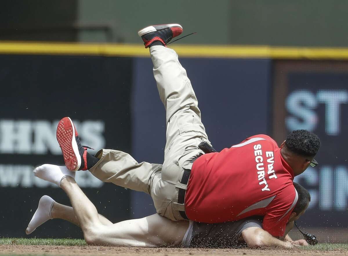 A security guard tackles a fan that ran on the field during the second inning of a baseball game between the Milwaukee Brewers and the San Francisco Giants Thursday, June 8, 2017, in Milwaukee. (AP Photo/Morry Gash)
