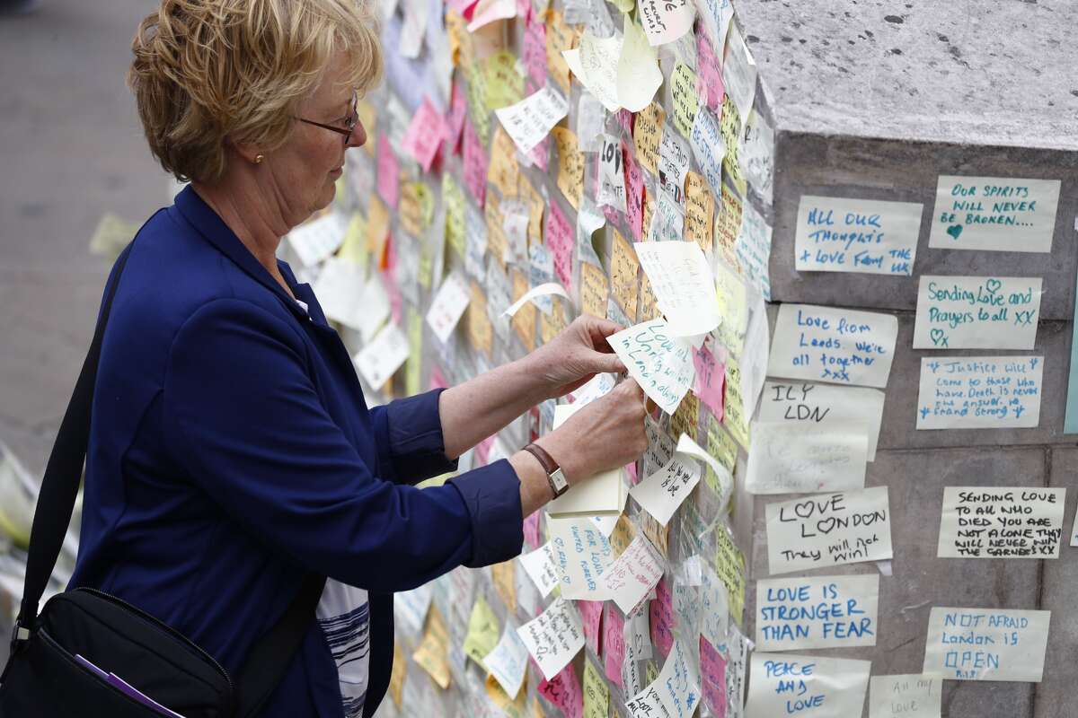 A Londoner adds a note to the memorial for the victims of the terrorist attack on London Bridge and in the Borough Market.