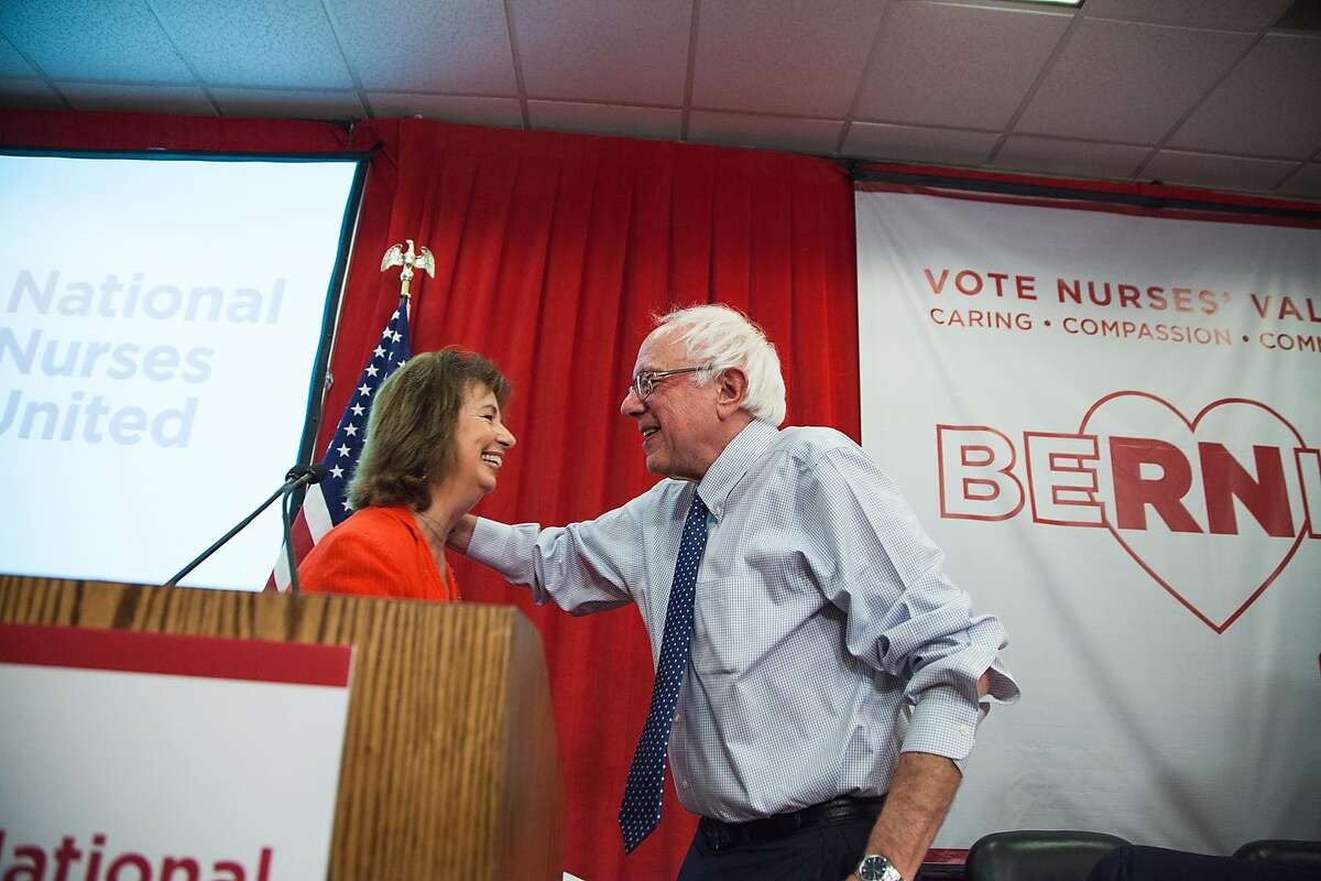 National Nurses United executive director RoseAnn Demoro hugs Vermont Sen. Bernie Sanders on Monday, Aug. 10, 2015, at NNU's headquarters in Oakland, California. NNU, the nationÂ’'s largest organization of nurses, hosted a Â“"Brunch with Bernie" where nurses throughout the nation joined by phone and in person to speak with Sanders.
