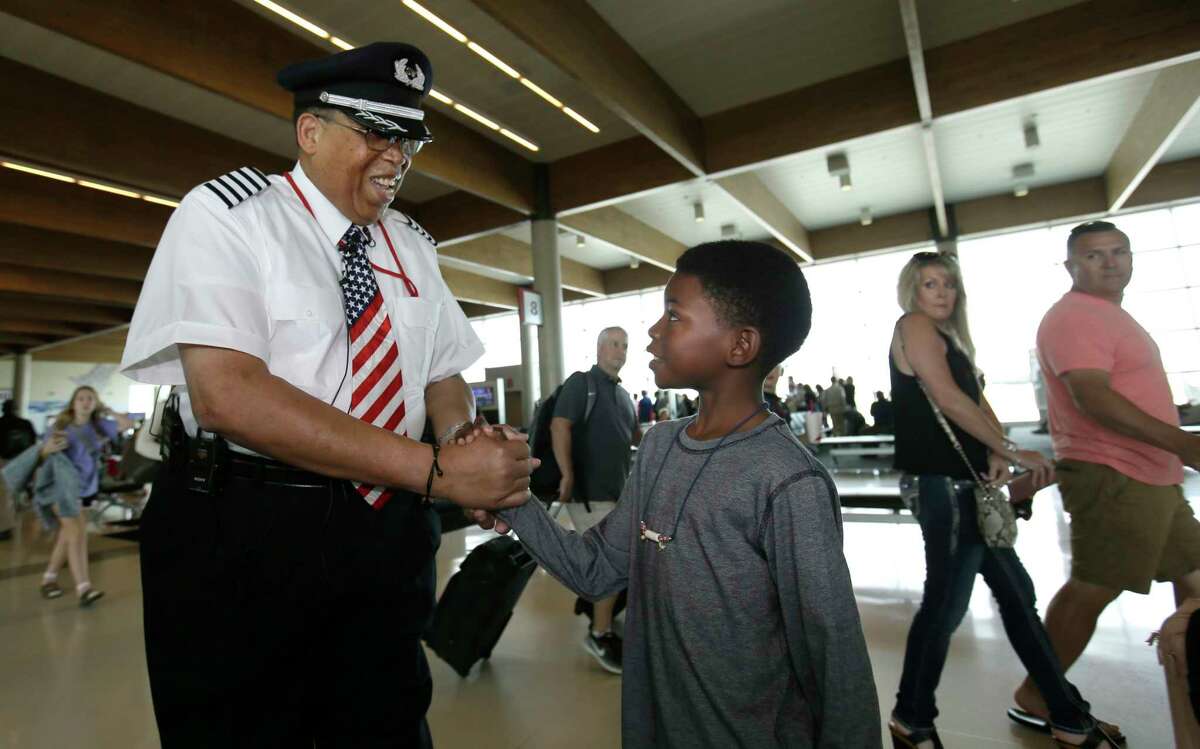 Christopher Goods, 10, offers congratulations to Southwest Airlines captain Louis Freeman on Thursday before he pilots his last flight for the airline.