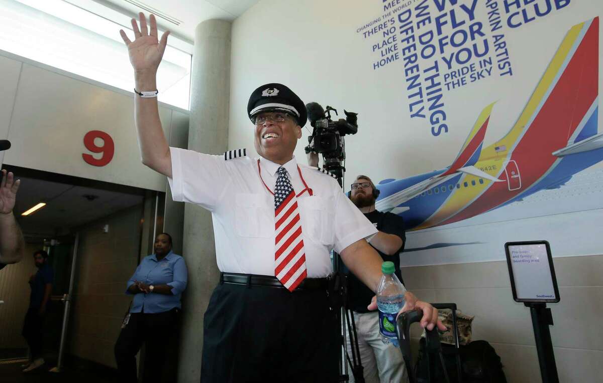 Southwest Airlines captain Louis Freeman waves before boarding a jet to fly his last flight for Southwest before his retirement in Dallas, Thursday, June 8, 2017. Freeman was the first African-American to become a chief pilot at a major U.S. airline and is retiring after a 36-year career that saw big changes in aviation. His most memorable flight carried the body of civil rights icon Rosa Parks. (AP Photo/LM Otero)