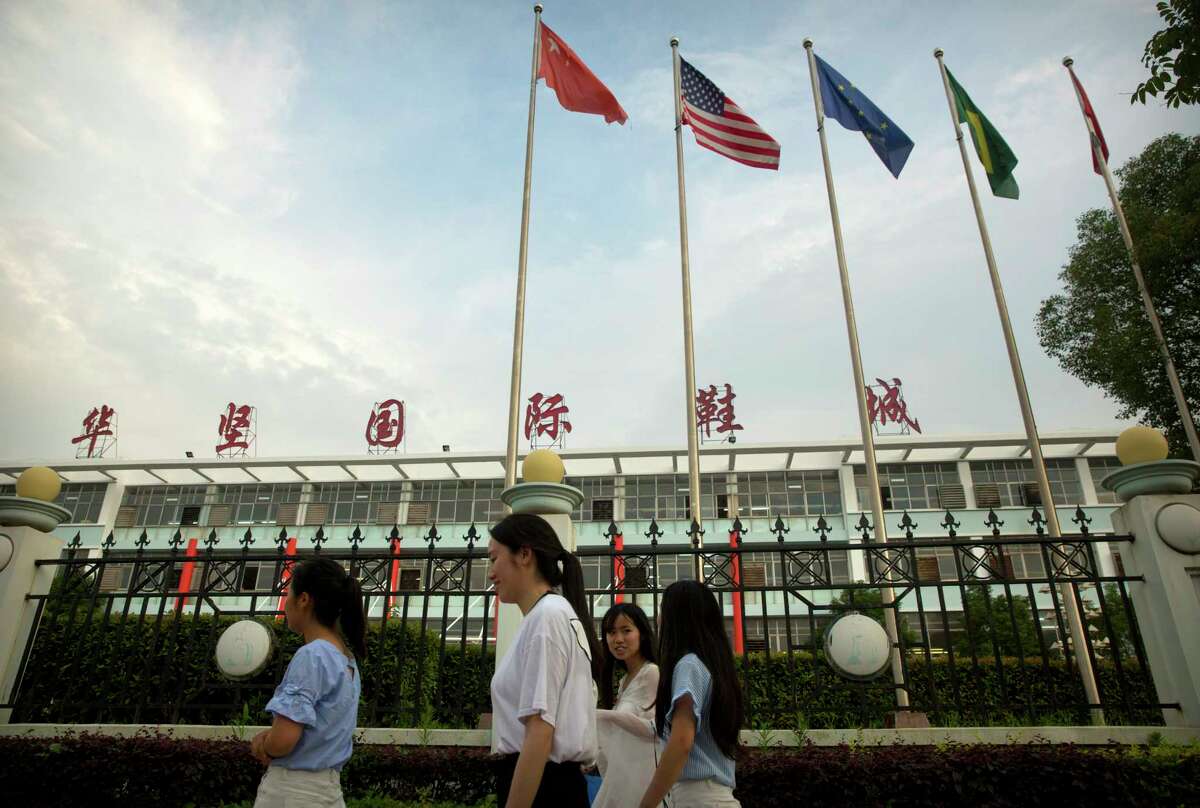 ﻿International flags fly at a Huajian Group shoe factory in Ganzhou in southern China's Jiangxi Province. The manufacturer has come under scrutiny after activists investigating labor conditions there were detained. ﻿