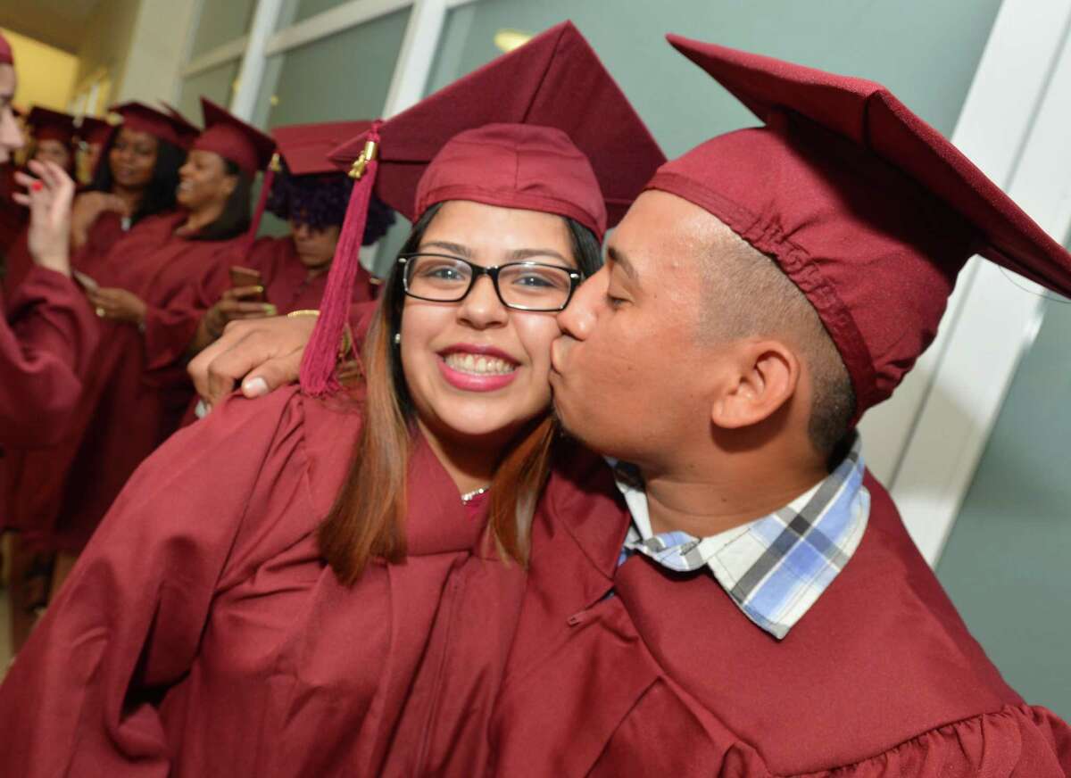 Husband and wife Jose and Sonny Mendiete share a kiss as they line up for the graduation ceremony.