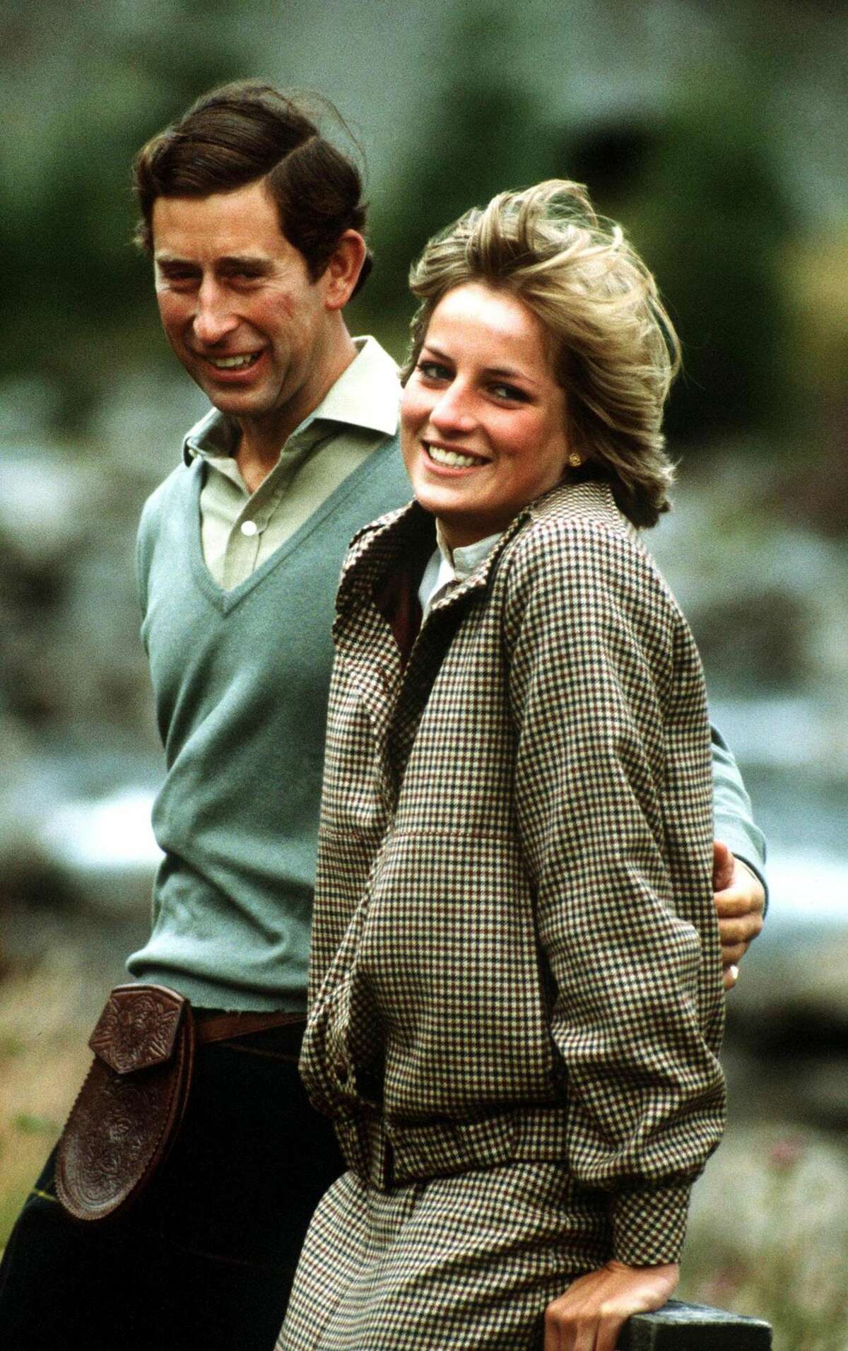 The Prince and Princess of Wales stand by the River Dee on the Balmoral estate during their honeymoon in Scotland, September 1981. The Princess wears a suit by Bill Pashley.