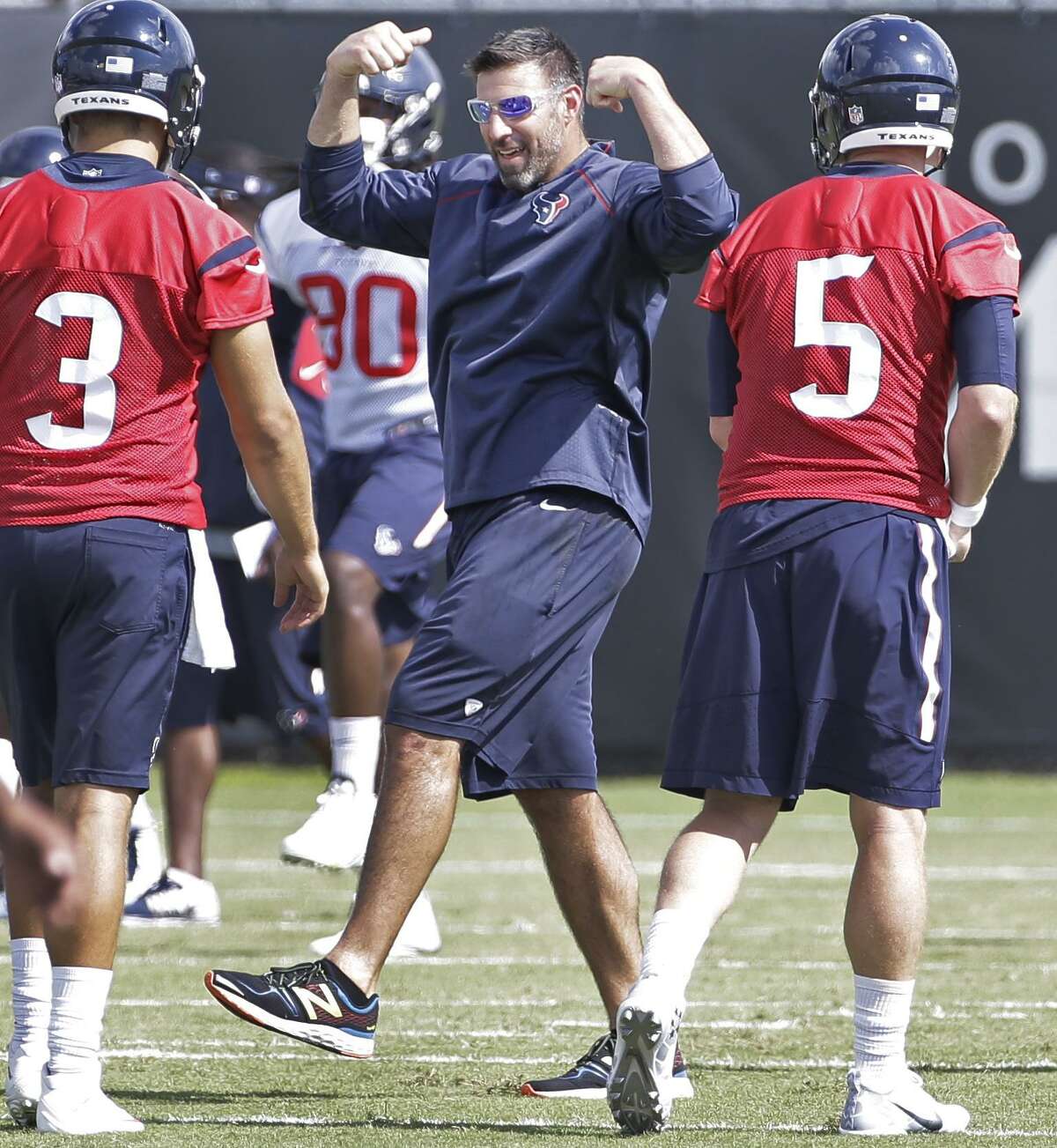Texans assistant coach Mike Vrabel (center) talks with Tom Savage (left) and Brandon Weeden (right) during offseason workouts at NRG Park on June 10, 2016, in Houston.