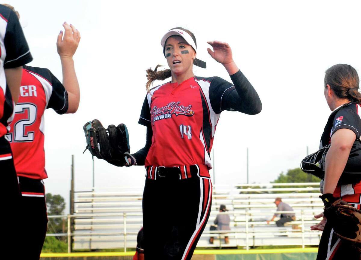 Pitcher Monica Abbott receives congratulations from teammates after striking out the side in the first inning during the Scrapyard Dawgs, Houston's new pro softball team, first home game at the Scrap Yard Sports Complex, 29607 Robinson Road in Spring. Photograph by David Hopper