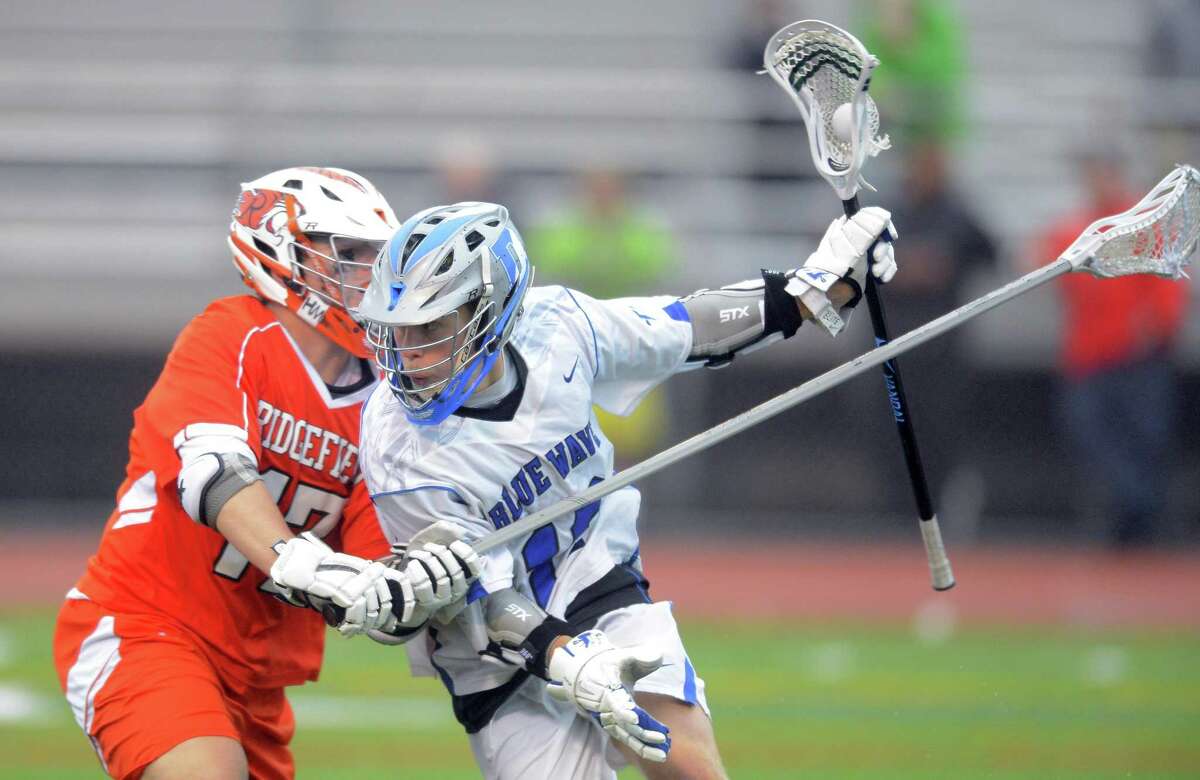 Darien Kevin Lindley drives under pressure from Ridgefield Noah Isaacson during the FCIAC boys lacrosse championship at Brien McMahon High School in Norwalk, Conn. on Thursday, May 25, 2017. Darien defeated Ridgefield 20-4.