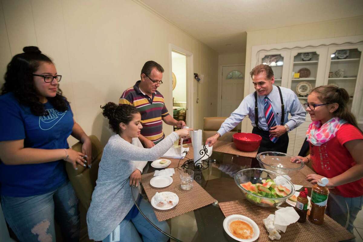 David Calvillo attorney at law and senior counsel at the Chamberlain Hrdlicka law firm shares a meal with Juan Rodriguez and his daughters, Rebecca Rodriguez, 15, Karen Rodriguez, 18, and Kimberly Rodriguez, 10, at their home in Houston, Thursday, June 8, 2017.