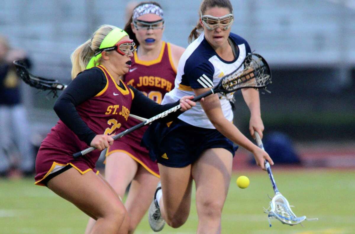 Weston's Taylor Moore and St. Joseph's Halle Grabowski chase down a loose ball during Class S girls lacrosse semifinal action in Trumbull, Conn., on Tuesday June 6, 2017.