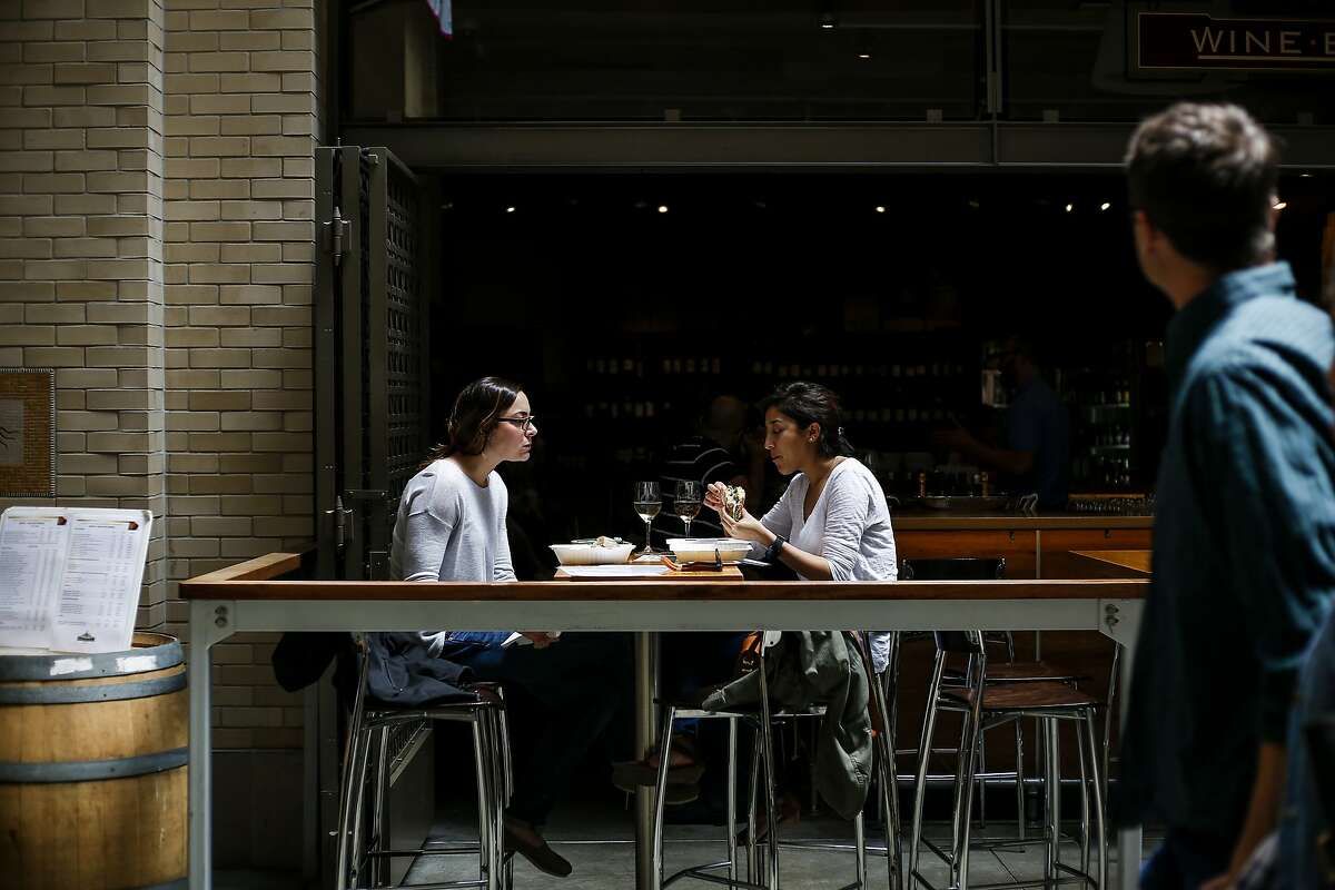 Sarah Ferreira, left, and Jacky Iniguez, right, eat lunch at the Ferry Plaza Wine Merchant inside the renovated marketplace in the Ferry Building in San Francisco on June 9, 2017.