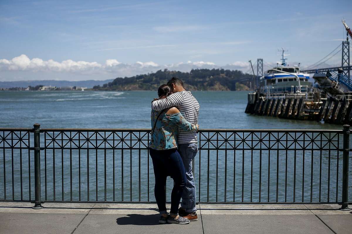 Daniel Diaz, right, and Beatriz Valvez, left, embrace outside the Ferry Building in San Francisco on June 9, 2017.
