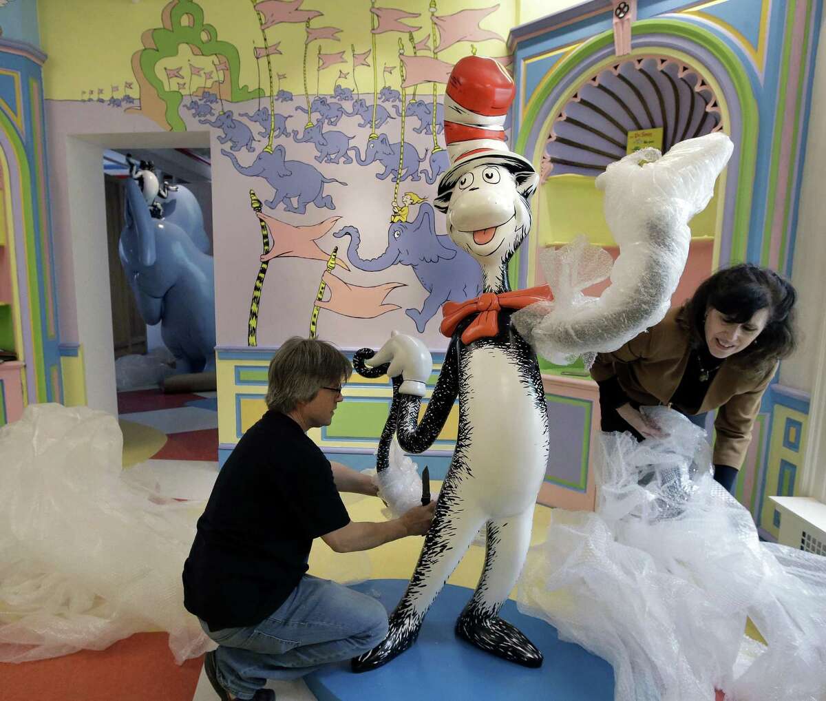 John Simpson (left), project director of exhibitions for The Amazing World of Dr. Seuss Museum, and his wife Kay Simpson (right), president of Springfield Museums, unwrap a statue of the "Cat in the Hat," at the museum in Springfield, Mass. The museum devoted to Dr. Seuss, which opened on June 3 in his hometown, features interactive exhibits, a collection of personal belongings and explains how the childhood experiences of the man, whose real name is Theodor Geisel, shaped his work.