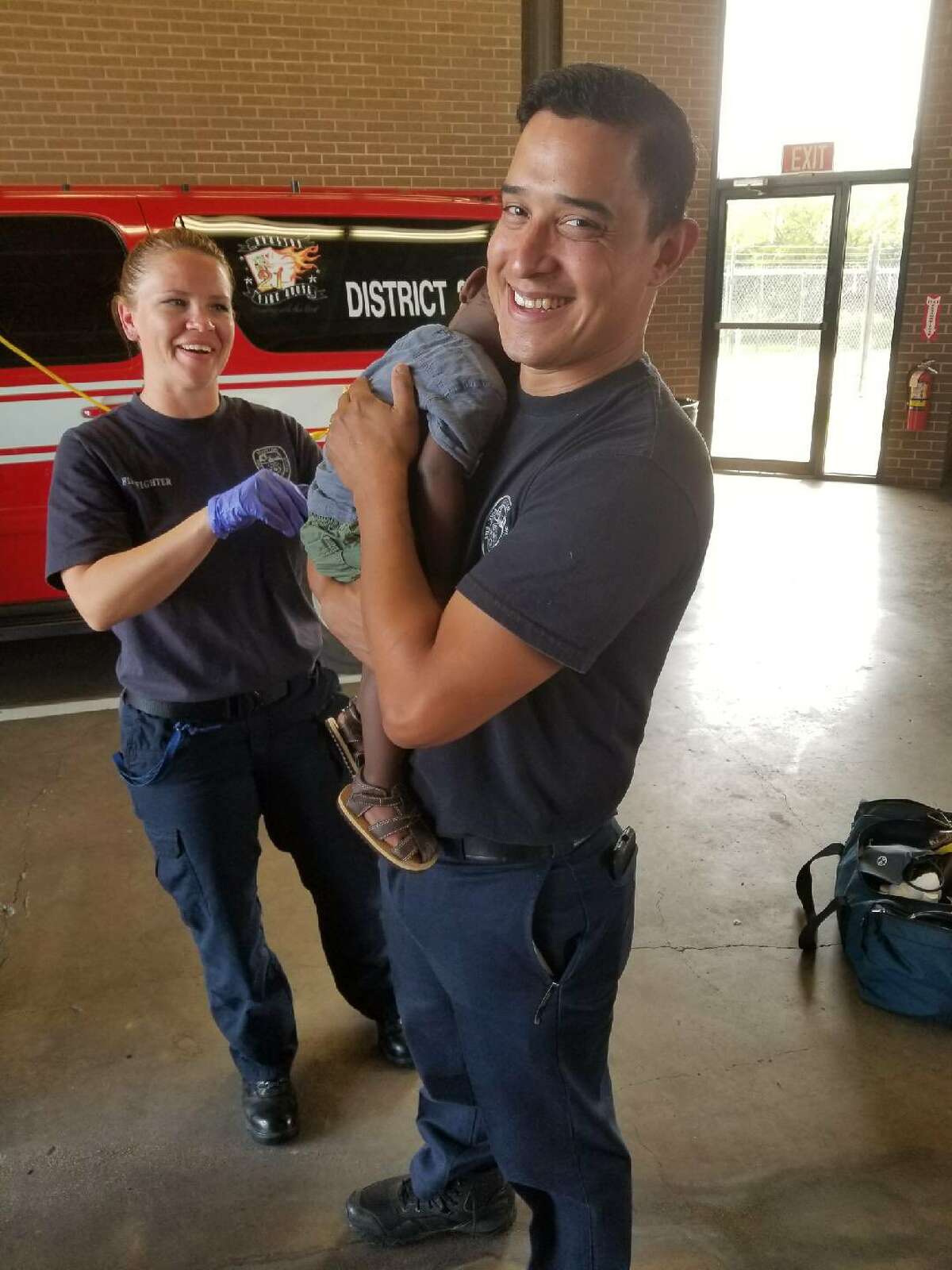 Houston firefighters care for a 1-year-old boy left at Station 21 on Friday. The child, who alerted the firefighters with his crying, appeared in good health.