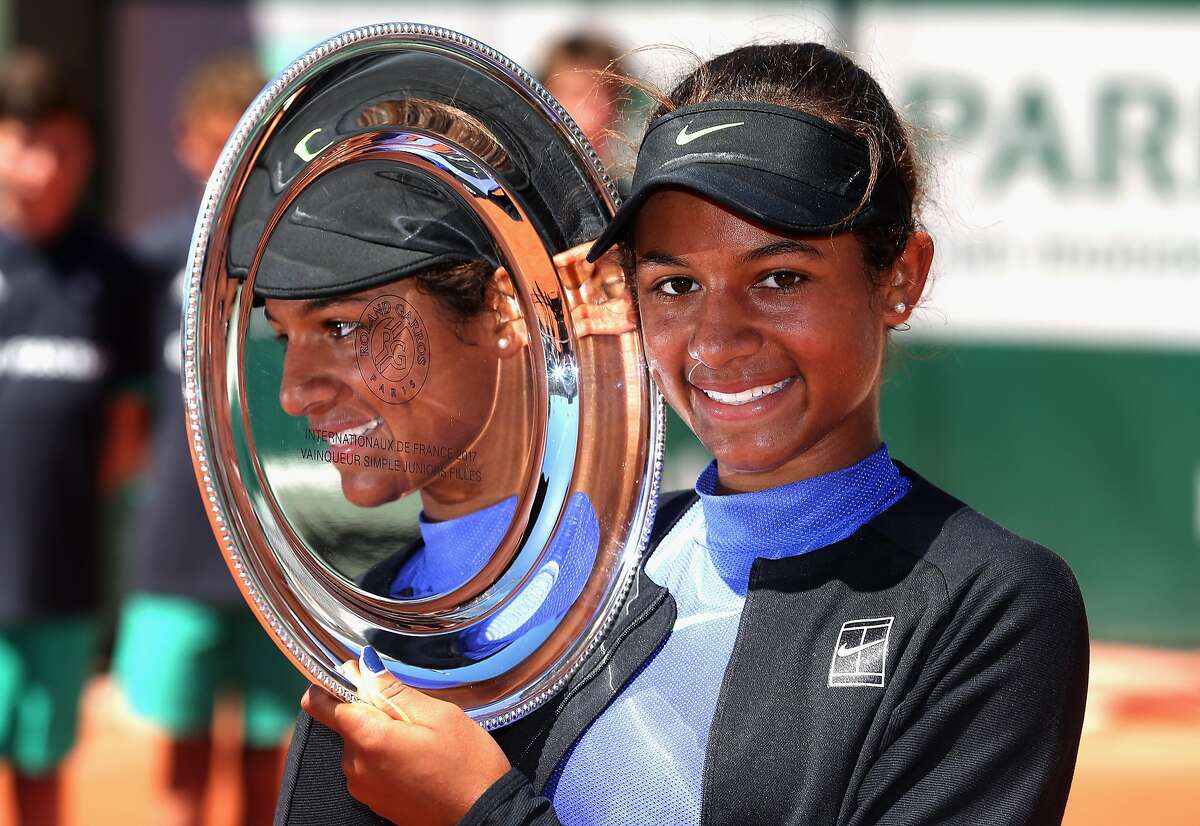 PARIS, FRANCE - JUNE 10: Whitney Osuigwe of The United States celebrates victory with the trophy following the girls singles final match gainst Claire Liu of The United States on day fourteen of the 2017 French Open at Roland Garros on June 10, 2017 in Paris, France. (Photo by Alex Pantling/Getty Images)