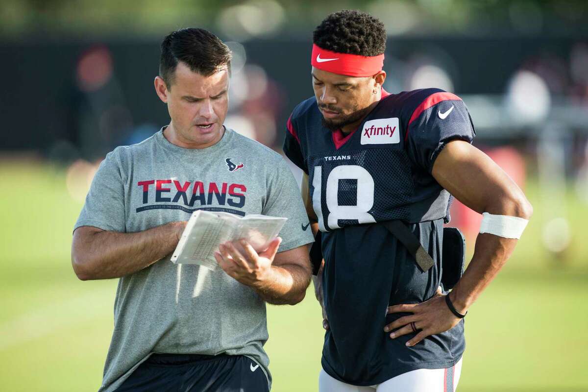 Sean Ryan, left, talking to Texans wide receiver Cecil Shorts during training camp last year, has been moved from wide receivers coach to quarterbacks coach.