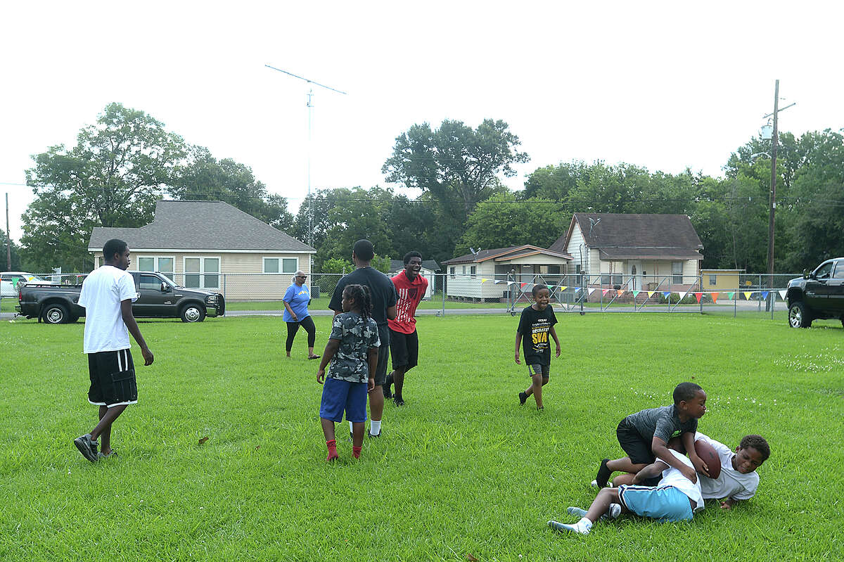 Friends get in a game of football at the NAACP's block party, held Saturday in Beaumont's Pear Orchard neighborhood. The event brought together family and friends for music, food, and games on the lawn, while offering a chance to hold a membership drive for the local chapter of the NAACP. Photo taken Saturday, June 10, 2017 Kim Brent/The Enterprise