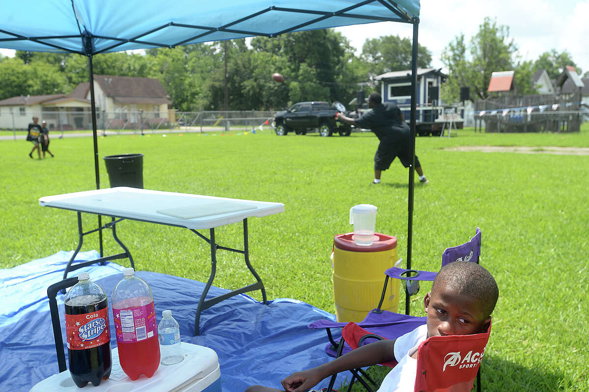 Twelve-year-old Jacquez Booker takes a break from football with friends and finds some shade under his family's awning at the NAACP's block party, held Saturday in Beaumont's Pear Orchard neighborhood. The event brought together family and friends for music, food, and games on the lawn, while offering a chance to hold a membership drive for the local chapter of the NAACP. Photo taken Saturday, June 10, 2017 Kim Brent/The Enterprise