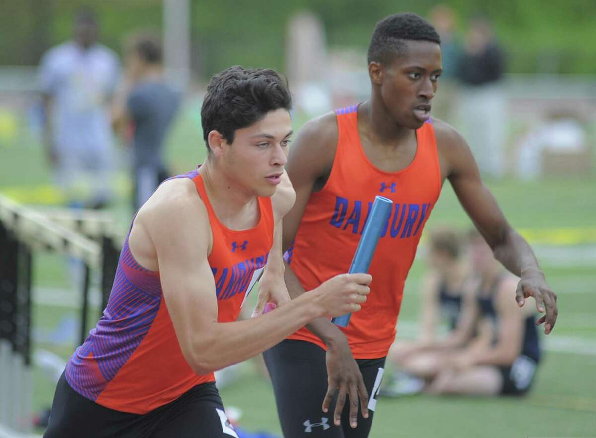 FILE PHOTO: Danbury’s Malcolm Going takes the handoff from Terrell Cuningham in the boys 4x400 meter relay run during the FCIAC boys track and field championship at Ridgefield High School on May 23, 2017.