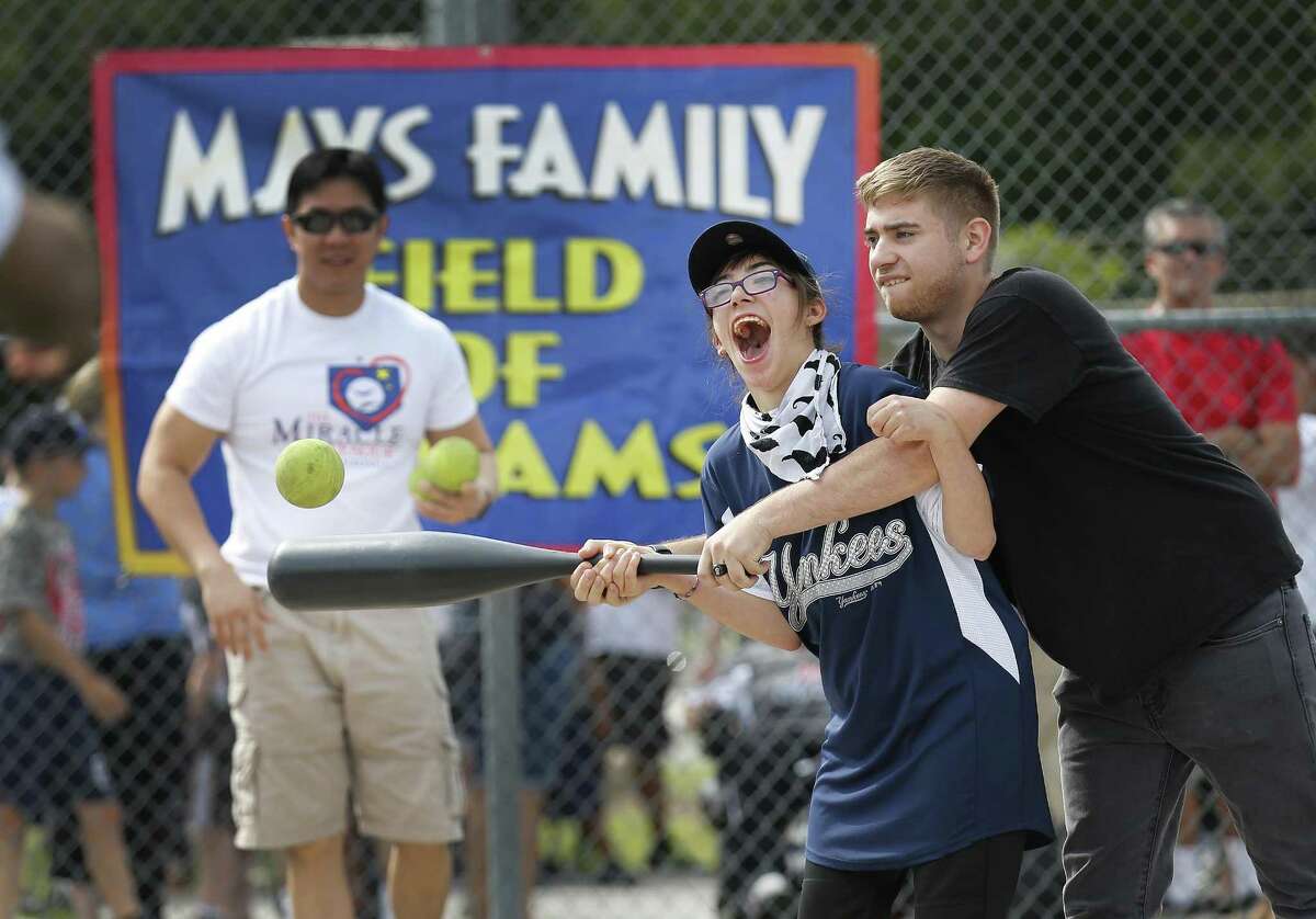 Kayla Janson, 17, gets assistance from her brother, Noah, in hitting the ball during a baseball game at the Miracle League of San Antonio on Saturday, June 10, 2017. The Miracle League of San Antonio - started by local attorney Mike Miller - gives special needs kids like Janson an opportunity to play the game of baseball in a supportive and fun environment. Six teams concluded their Spring season with each child getting a swing at bat with family and friends cheering them on. At the end, the children received trophies for their participation. (Kin Man Hui/San Antonio Express-News)