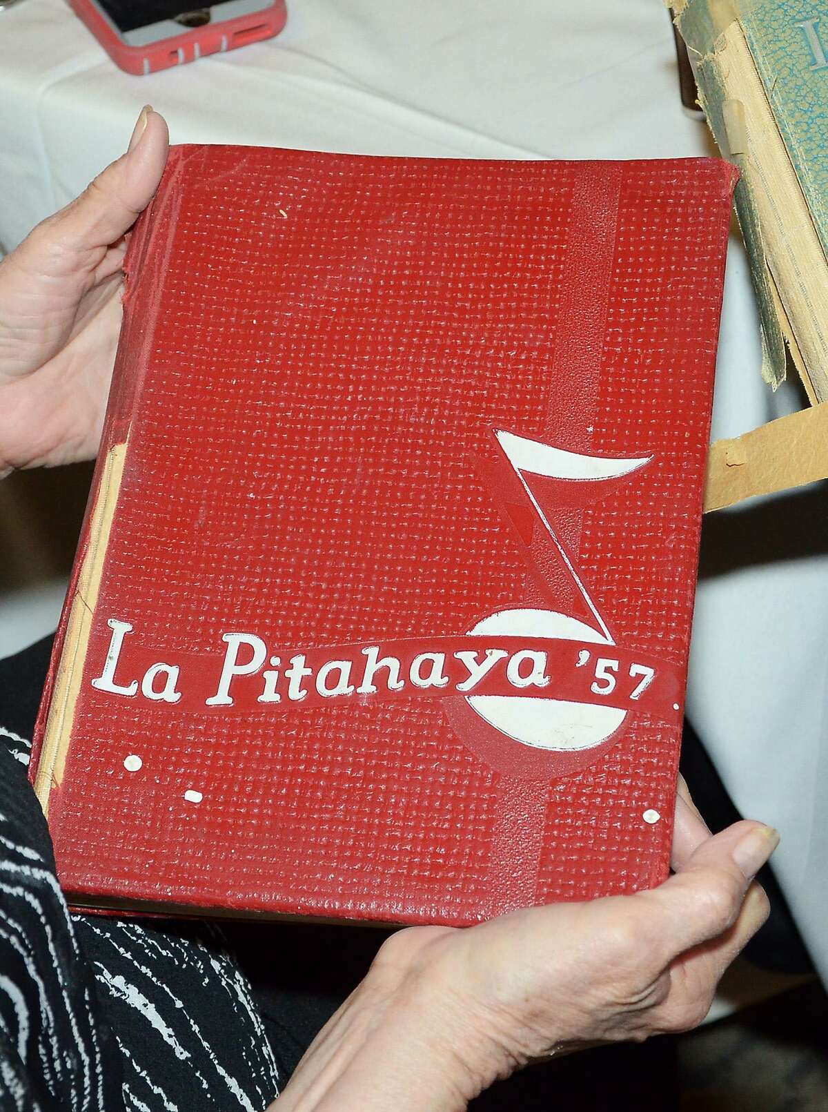 Una estudiante de la generación de 1957 de la preparatoria Martin High School sostiene una copia del anuario escolar La Pitahaya durante la 60ava. reunión de generación que se llevó a cabo el sábado en Embassy Suites.