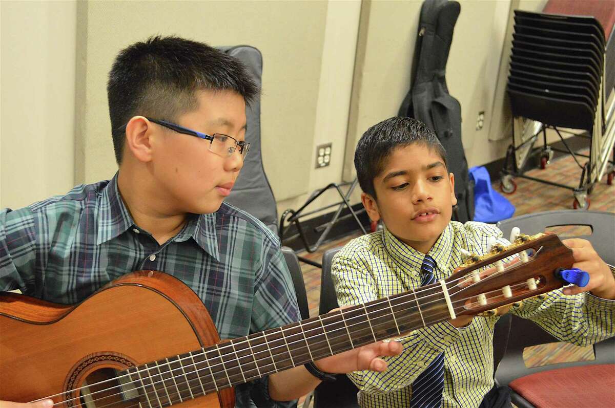 Arnav Chaudhary, 10, of New Cananaa, helps Andy Li, 11, of New Canaan, with his tuner at New Canaan Public Schools' Celebration of the Arts Gala Concert at New Canaan High School, Friday, June 9, 2017, in New Canaan, Conn.