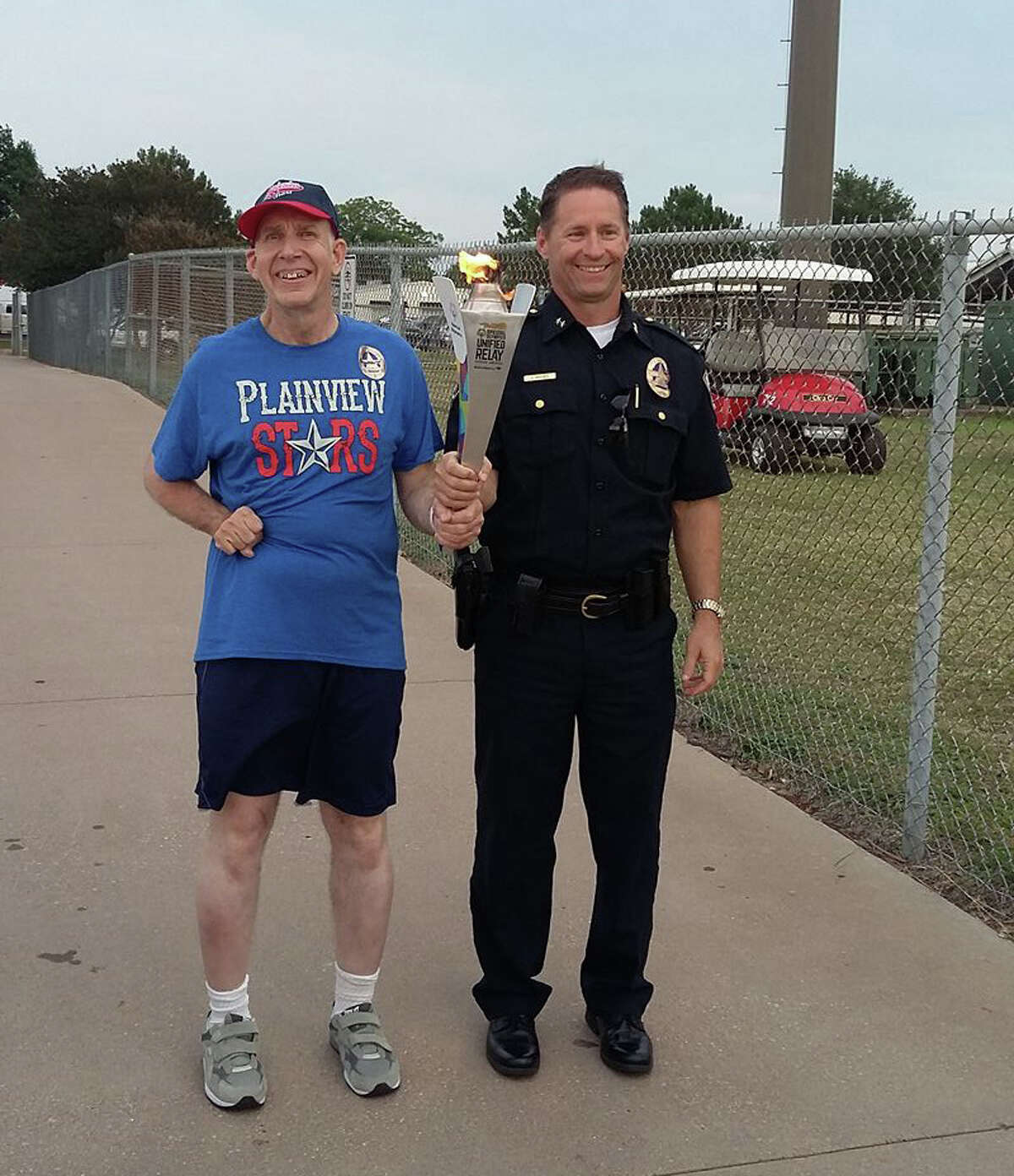 Lynn Mason and Chief Jeff Spivey, Irving Police Department, bringing the Flame of Hope at the State Summer Games.