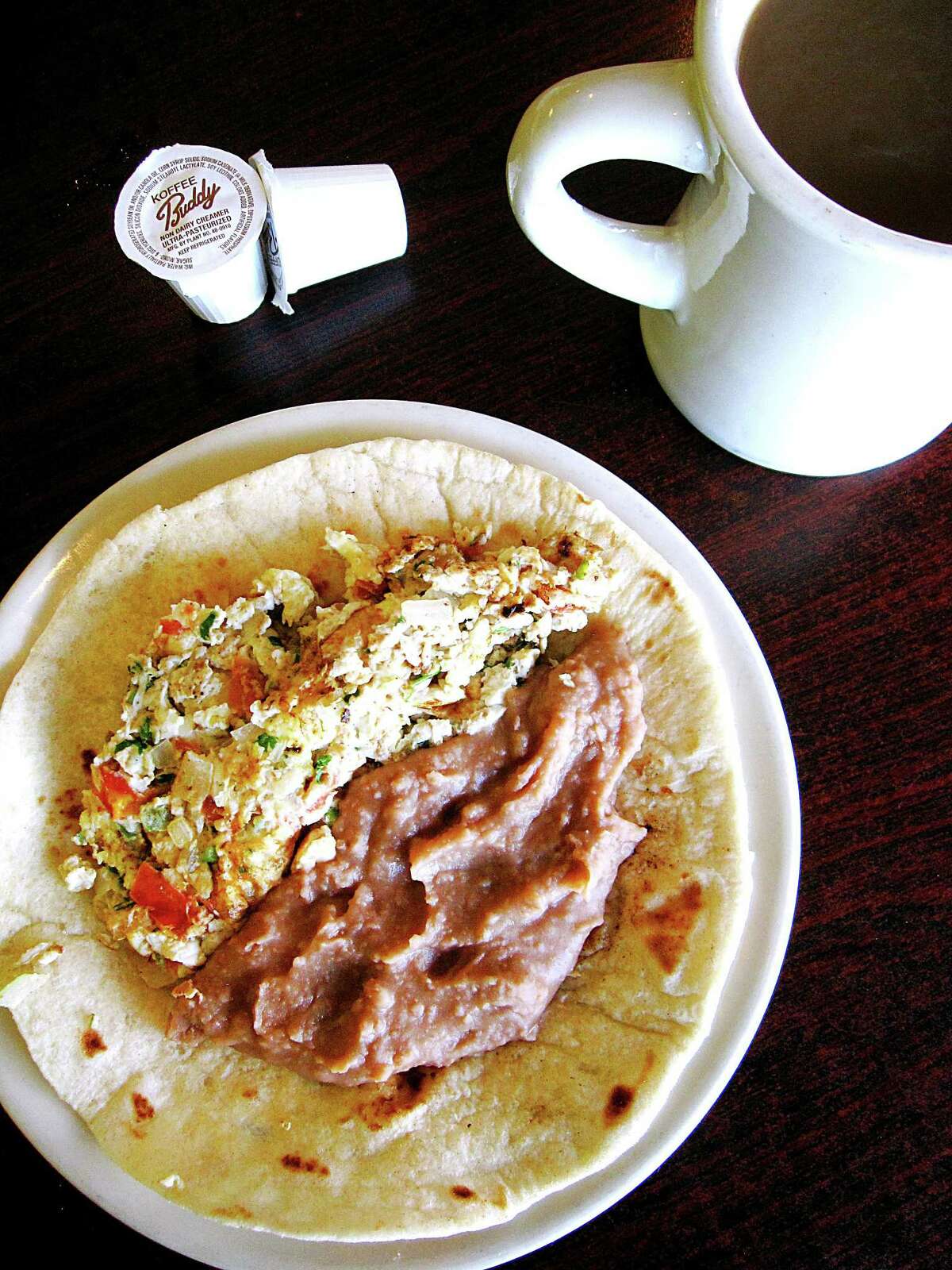 Huevos a la mexicana taco with beans on a handmade flour tortilla and a hot cup of cafe de olla with cinnamon and brown sugar from Las Sabrosas de Guanajuato.