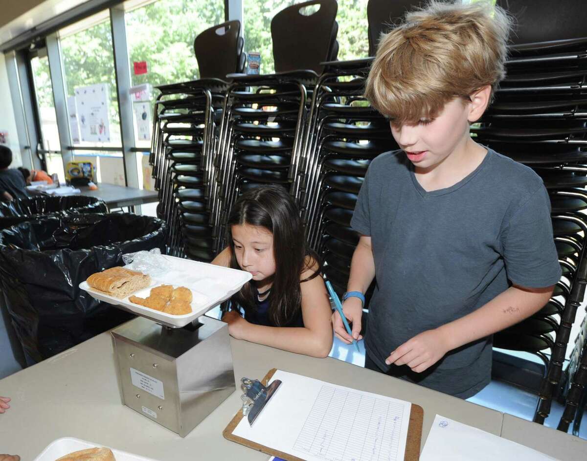 Hamilton Avenue School fourth grade students Pearl Lee, 9, left, and Jack Magill, 10, weigh lunch items to see how much food waste has been decreased by directing it toward the composting program that is in effect at the school in the Chickahominy section of Greenwich, Conn., Friday, June 9, 2017.