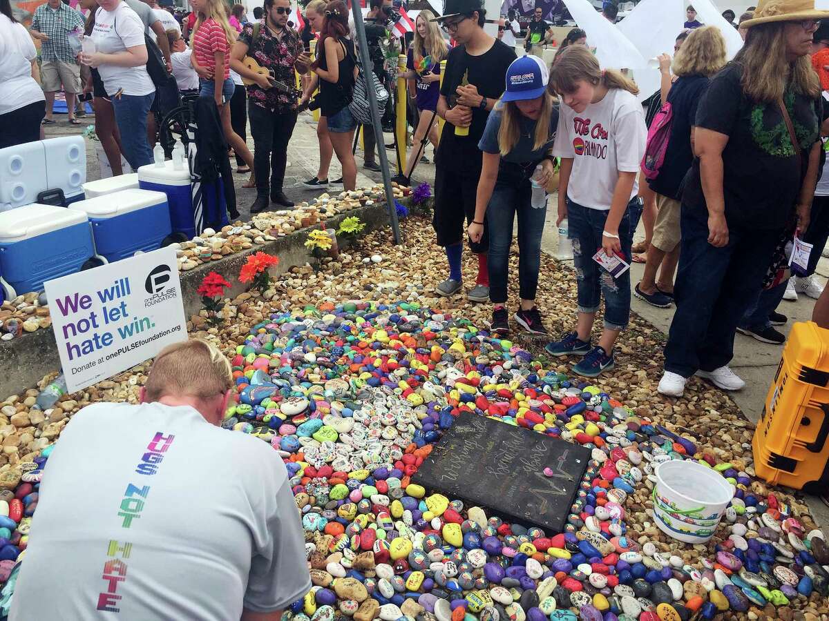 People attend the "Hugs Not Hate" heart memorial outside Pulse nightclub in Orlando, Fla., Monday, June 12, 2017, in honor of the 49 people who lost their lives in the shooting one year ago. (Kayla O'Brien/Orlando Sentinel via AP)