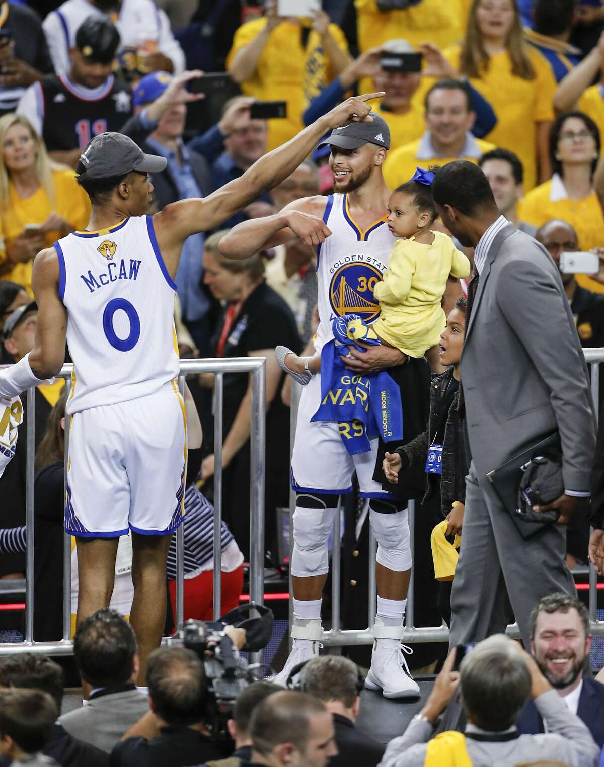Golden State Warriors' Stephen Curry holds daughter, Ryan, as Patrick McCaw celebrates after the Golden State Warriors defeated the Cleveland Cavaliers 129-120 in Game 5 to win the 2017 NBA Finals at Oracle Arena on Monday, June 12, 2017 in Oakland, Calif.