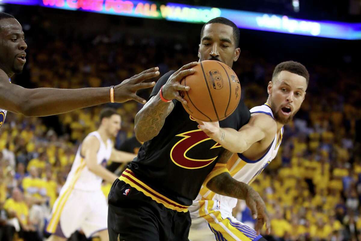 The Warriors' Stephen Curry, right, and the Cavaliers' J.R. Smith battle for a loose ball during the Game 5 finale.