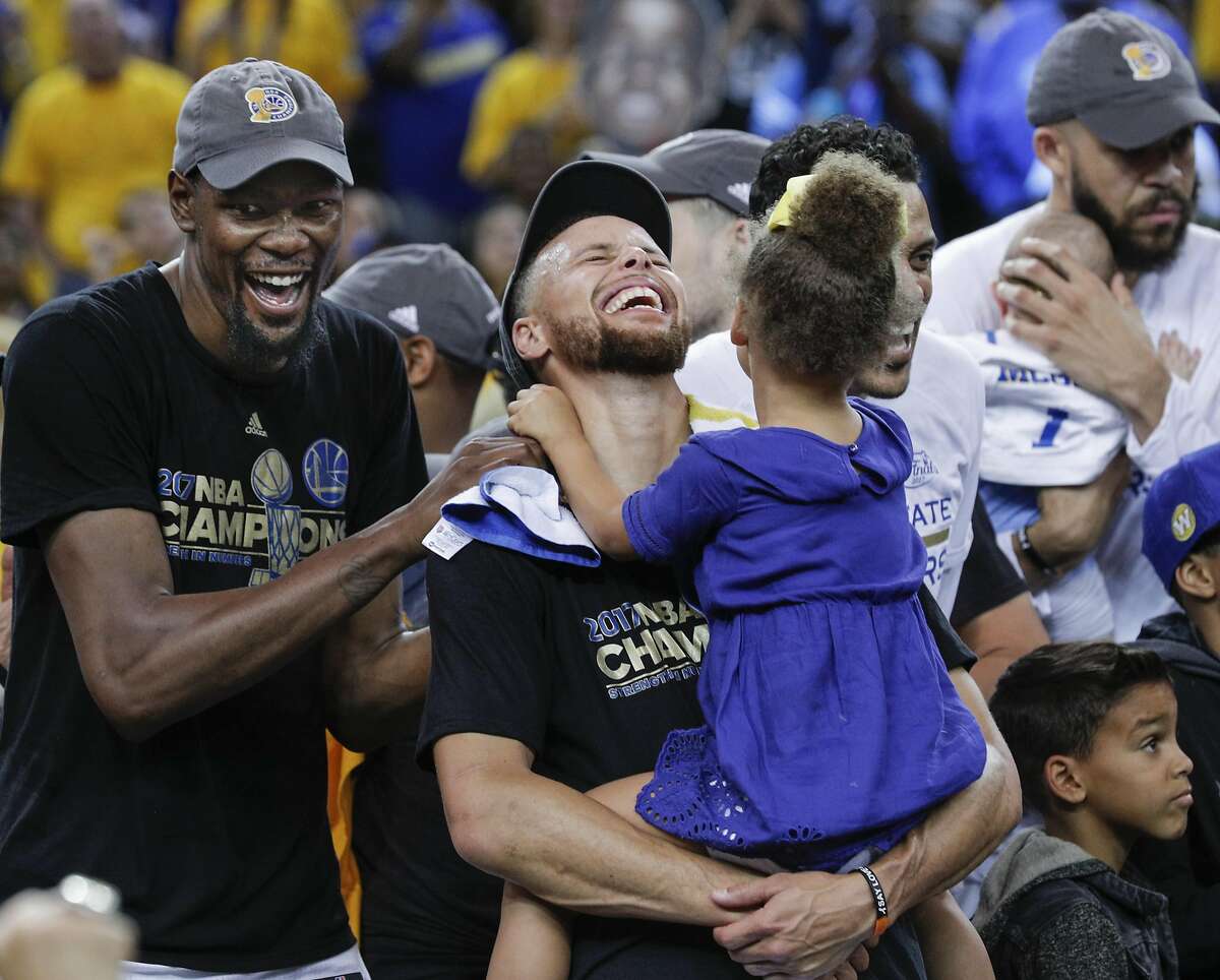 Golden State Warriors' Kevin Durant and Stephen Curry laugh while celebrating the Golden State Warriors win over the Cleveland Cavaliers in the 2017 NBA Finals at Oracle Arena on Monday, June 12, 2017 in Oakland, Calif.