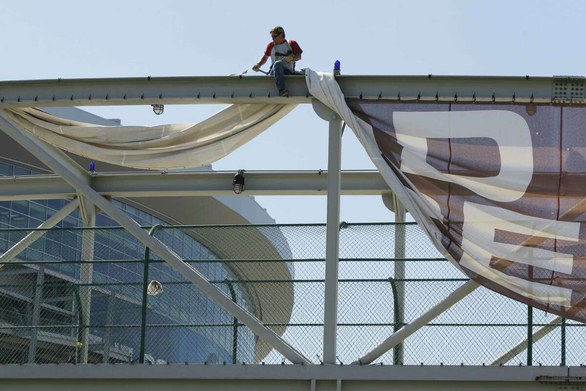 Mark Wallman of Houston with Hendee Enterprises taking down a Final Four banner on the pedestrian bridge over Kirby between Murworth and McNee Tuesday, April 5, 2011, in Houston.( Melissa Phillip / Houston Chronicle )