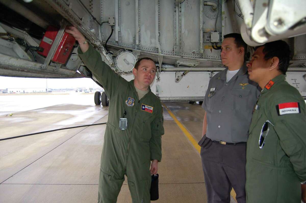 Two pilots from Brazil (center) and Indonesia (right), learn about the fire-suppression control panel on the C-5A Galaxy from 2nd Lt. Mike Blakley, is a C-5A pilot assigned to the 68th Airlift Squadron, 433rd Airlift Wing at Port San Antonio. Both pilots are students at the Defense Language Institute Foreign Language Center located on Joint Base San Antonio-Lackland. Four pilots from the center visited the wing to learn more about flying the C-5 from those pilots who actually fly the massive jet.