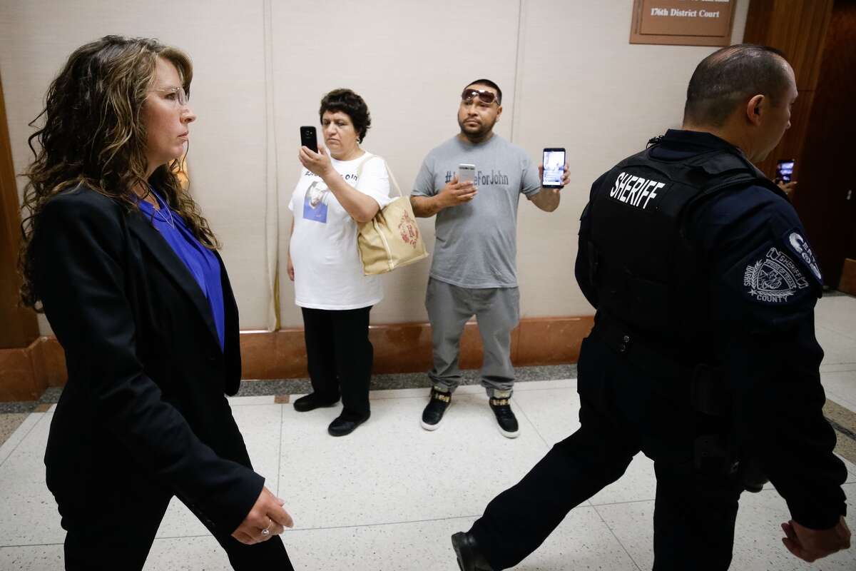 Harris County Sheriff's deputy Chauna Thompson, left, walks past supporters of John Hernandez as she is escorted by a deputy while at court Tuesday, June 13, 2017. She and her husband, Terry Thompson, were indicted on murder charges in the death of John Hernandez, who died in the hospital on May 31 following the May 28 confrontation with the couple outside a Denny's restaurant. A medical examiner ruled that he died of lack of oxygen to the brain caused by strangulation and chest compression.