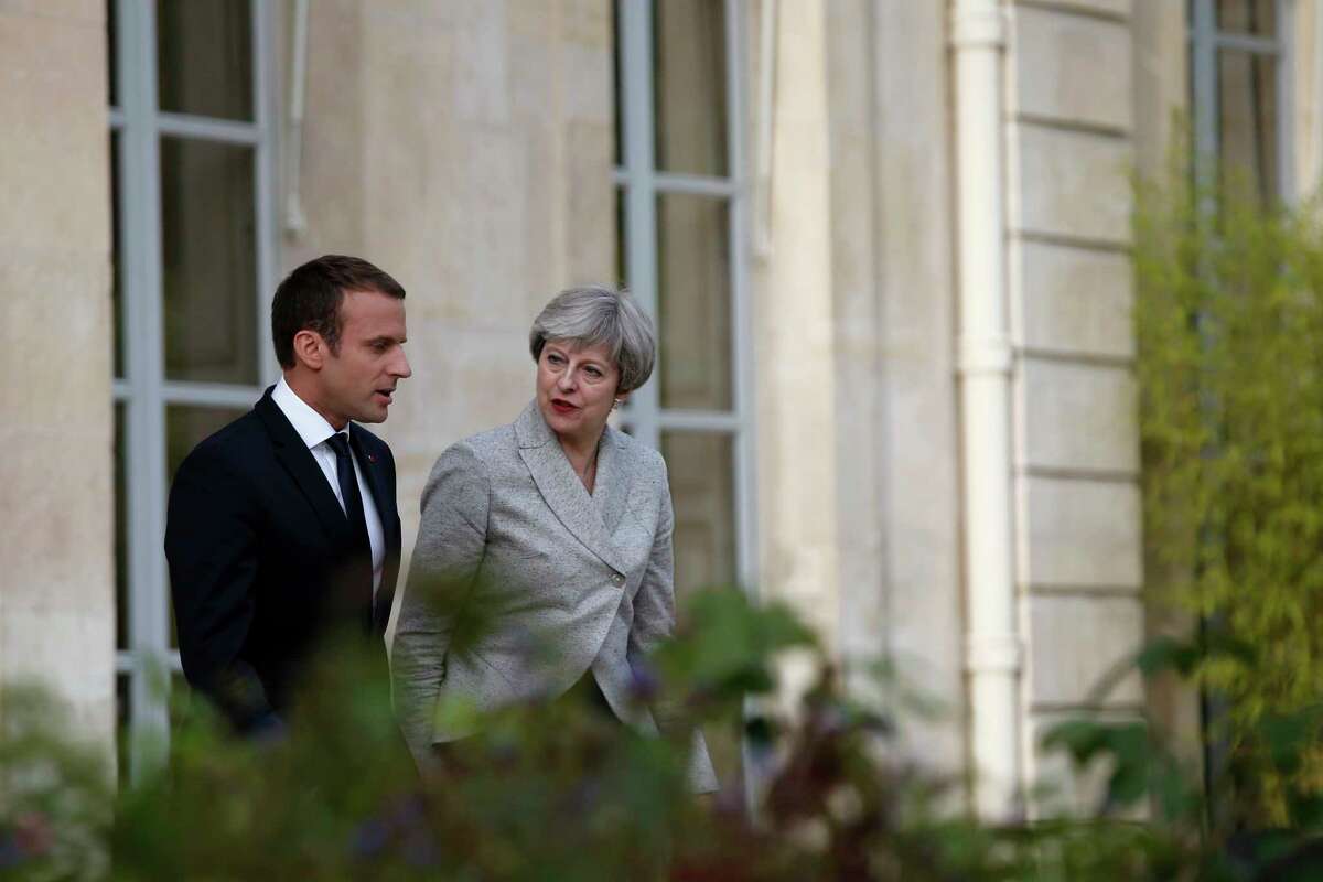 French President Emmanuel Macron, left, and Britain's Prime Minister Theresa May arrive for a joint press conference after a meeting, at the Elysee Palace, in Paris, Tuesday, June 13, 2017. After their talks, the two leaders will watch a France-England football match at the Stade de France that will honor victims of extremist attacks in both countries. (AP Photo/Thibault Camus)