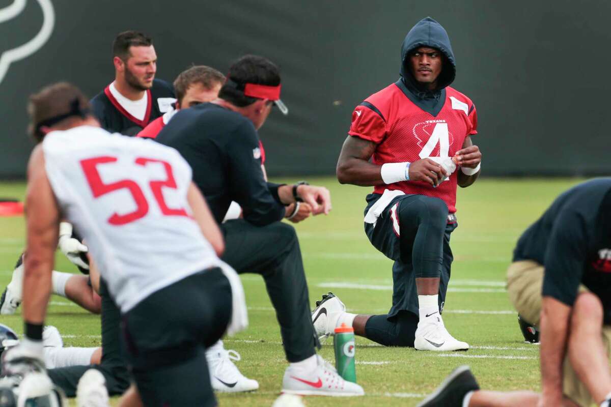 Rookie quarterback Deshaun Watson, right, stretches his muscles and fashion sense during Texans minicamp Tuesday.