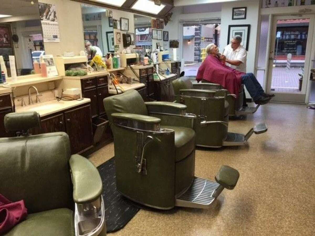 Leon Apostolo shaves a customer at Shepard's Barber Shop. The old-style barber chairs are pictured here and serve as a part of the shop's nostalgic feel.