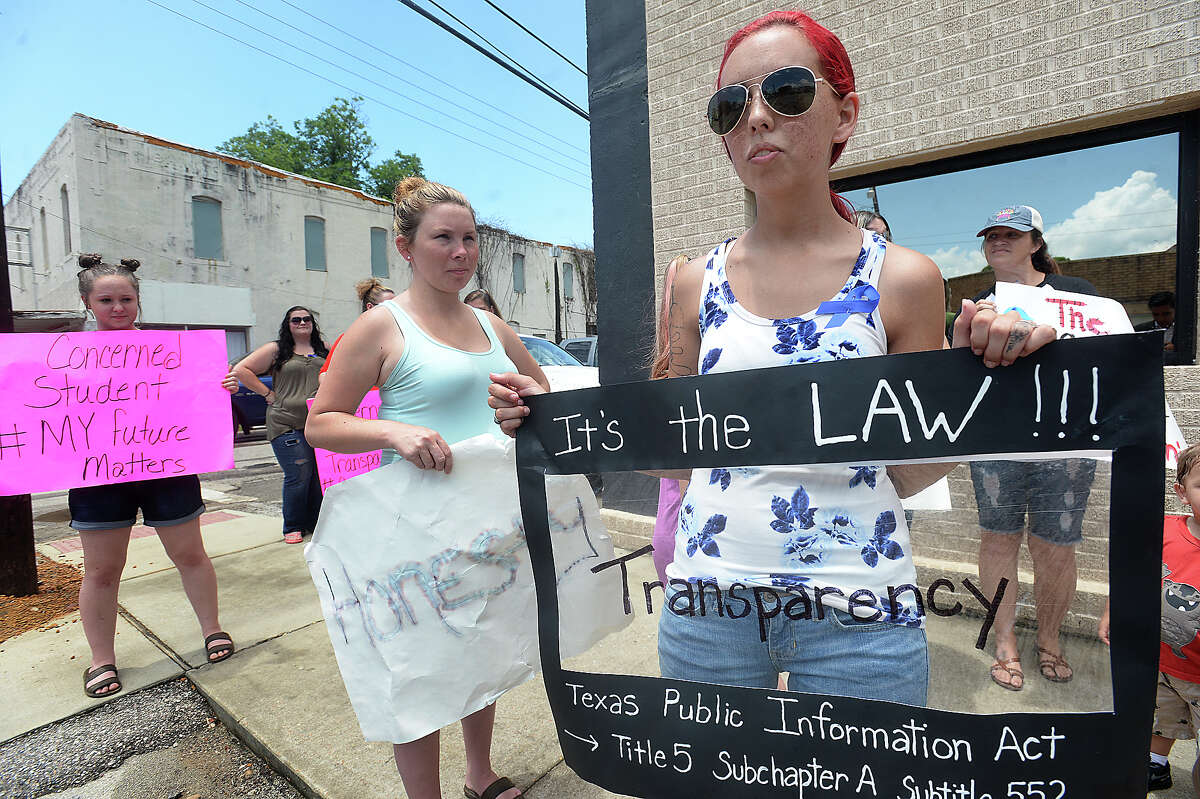 A group of concerned Kirbyville citizens, including Tyler Coleman(right), hold signs asking for transparency and truth outside the Kirbyville CISD administration building as the school board met with their attorney in a closed session meeting Tuesday. The meeting was to discuss the pending litigation related to high school principal Dennis Reeves' death. The group has called themselves "Community for Change" and say they will attend all the school board meetings from here on to make their presence and call for answers known, as well as to seek justice for the Reeves family. Photo taken Tuesday, June 13, 2017 Kim Brent/The Enterprise
