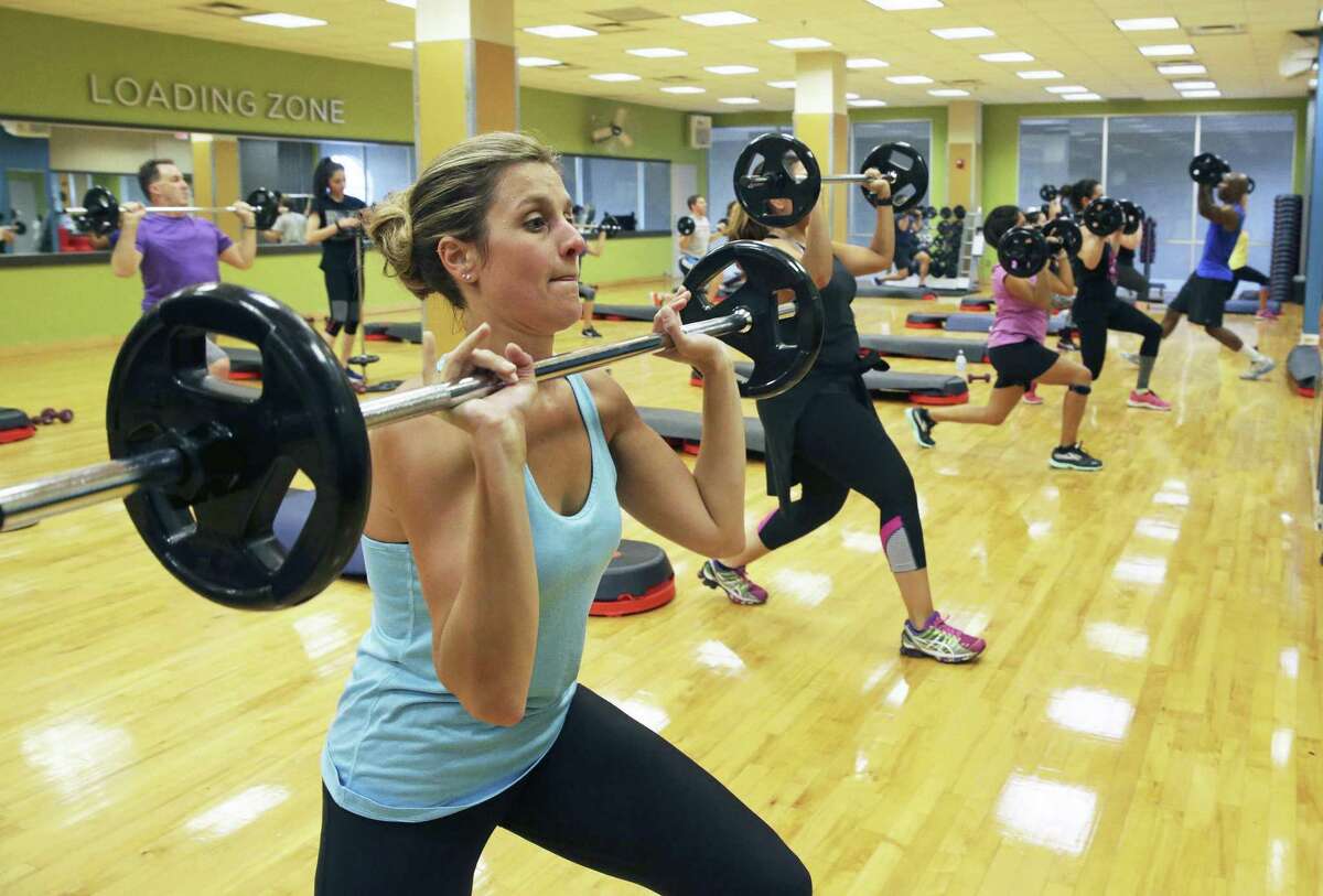 Emily Noll lifts with the group as patrons at Gold's Gym in the Alamo Quarry Market. During high-intensity interval training, work periods can range from 30 seconds to as long as three minutes, depending on fitness level.