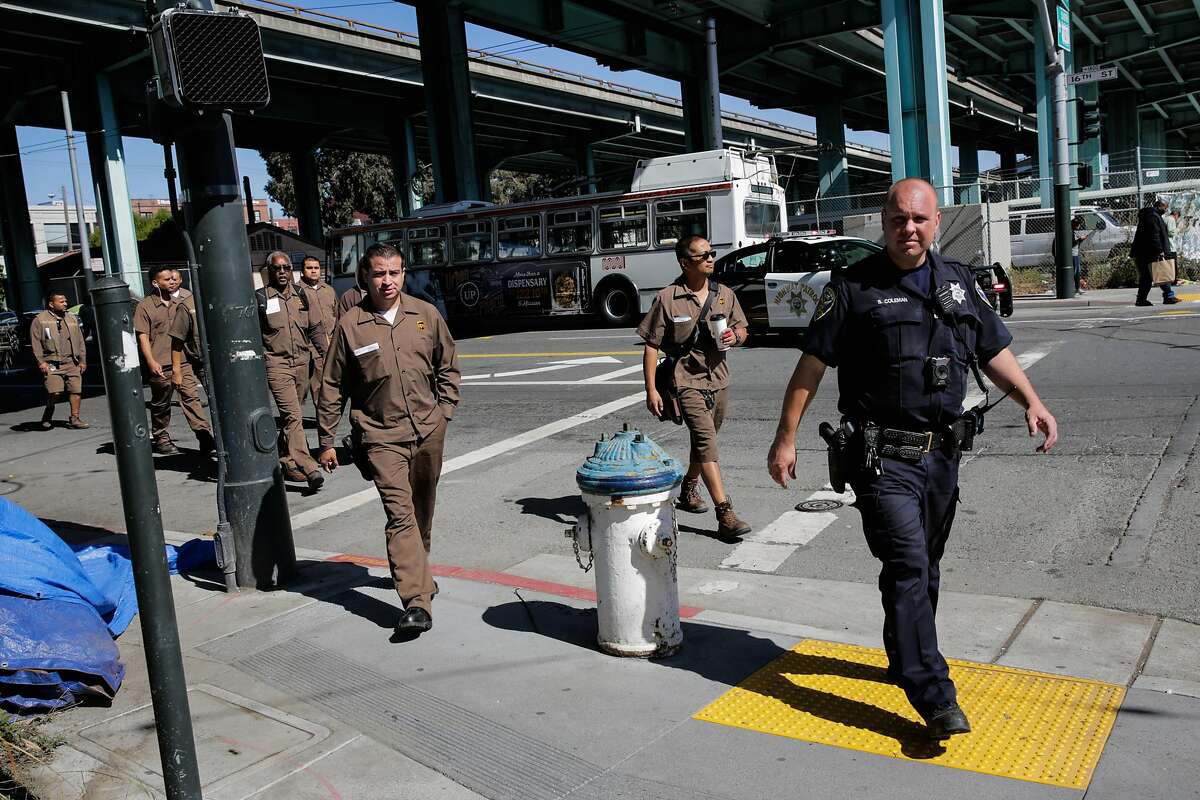 A police officer escorts UPS workers out of their building at the scene of an active shooting at 16th Street and Vermont Street in San Francisco, California, on Wednesday, June 14, 2017.